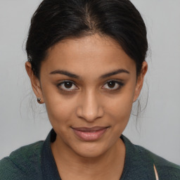 Joyful latino young-adult female with medium  brown hair and brown eyes