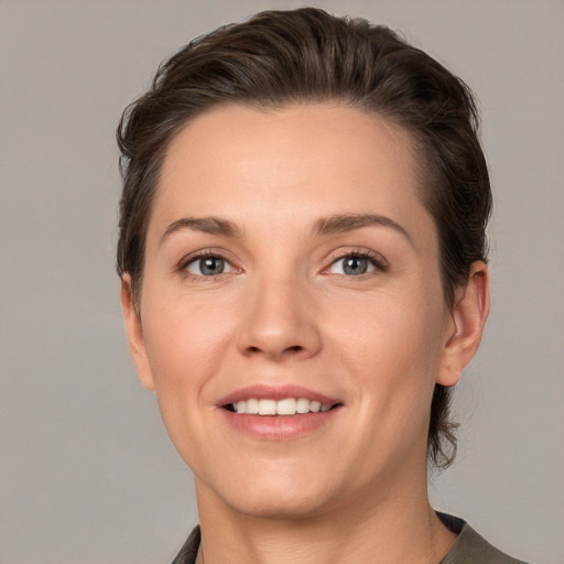 Joyful white young-adult female with short  brown hair and grey eyes