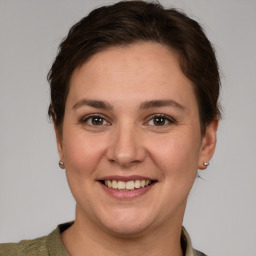 Joyful white young-adult female with short  brown hair and grey eyes