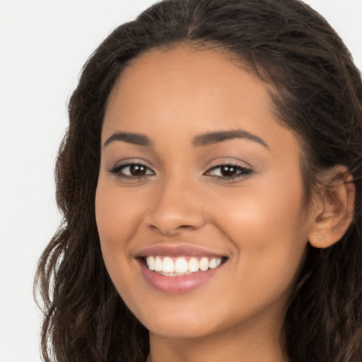 Joyful latino young-adult female with long  brown hair and brown eyes