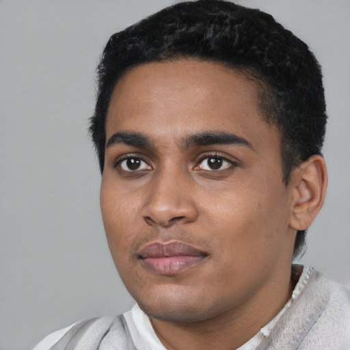 Joyful black young-adult male with short  black hair and brown eyes