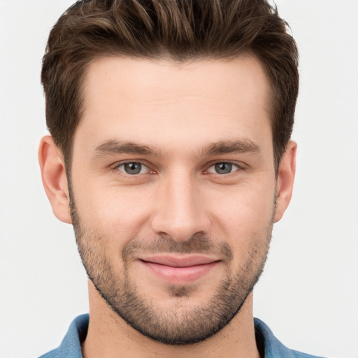 Joyful white young-adult male with short  brown hair and grey eyes