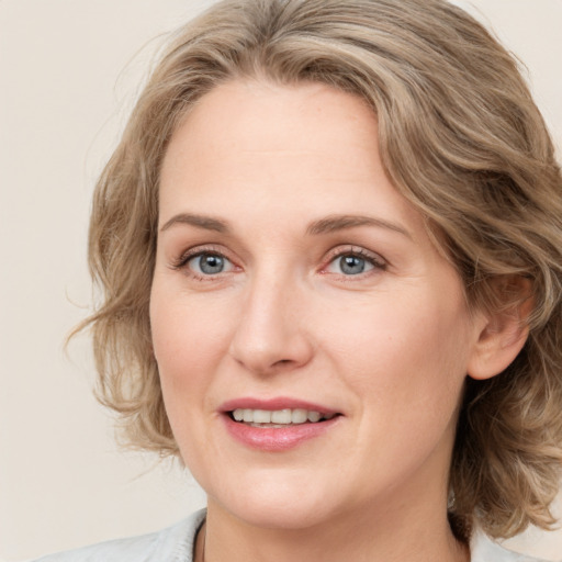 Joyful white young-adult female with medium  brown hair and blue eyes