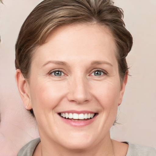 Joyful white young-adult female with medium  brown hair and blue eyes