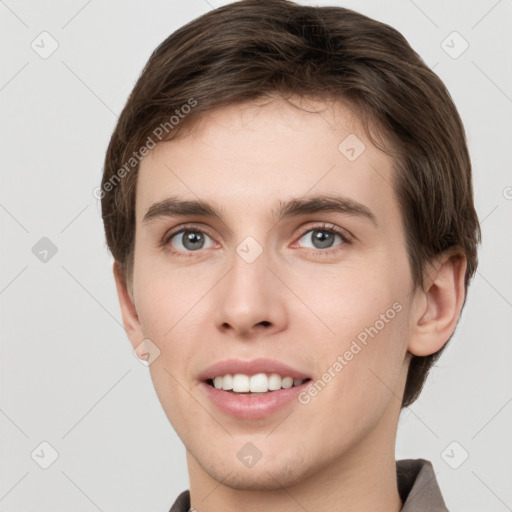 Joyful white young-adult male with short  brown hair and grey eyes