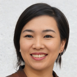 Joyful asian young-adult female with medium  black hair and brown eyes