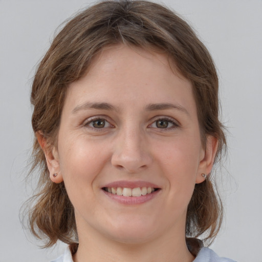 Joyful white young-adult female with medium  brown hair and grey eyes