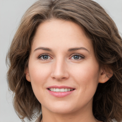 Joyful white young-adult female with medium  brown hair and green eyes