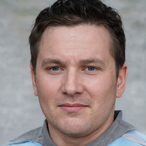 Joyful white adult male with short  brown hair and grey eyes