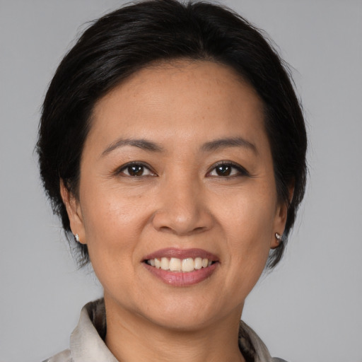 Joyful asian adult female with medium  brown hair and brown eyes