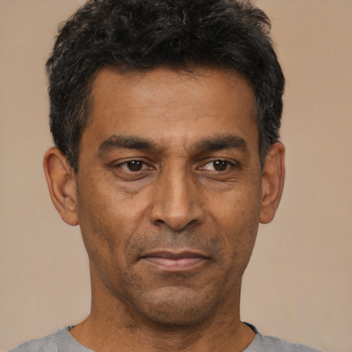 Joyful latino adult male with short  black hair and brown eyes