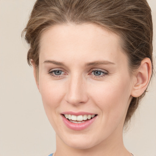 Joyful white young-adult female with medium  brown hair and grey eyes