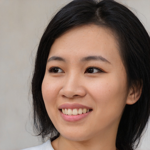 Joyful asian young-adult female with medium  black hair and brown eyes