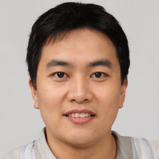 Joyful asian young-adult male with short  black hair and brown eyes