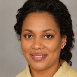 Joyful black adult female with medium  brown hair and brown eyes