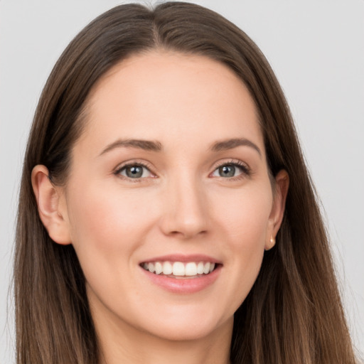 Joyful white young-adult female with long  brown hair and grey eyes