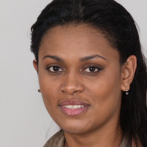 Joyful black young-adult female with long  brown hair and brown eyes