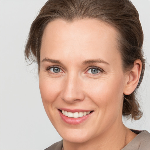 Joyful white young-adult female with medium  brown hair and grey eyes