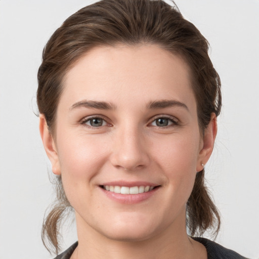 Joyful white young-adult female with medium  brown hair and grey eyes