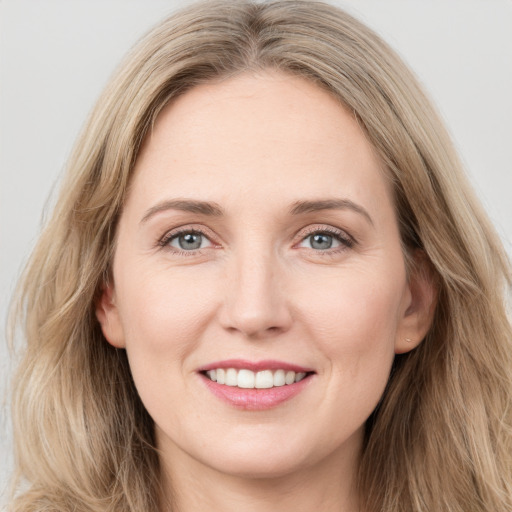 Joyful white young-adult female with long  brown hair and grey eyes