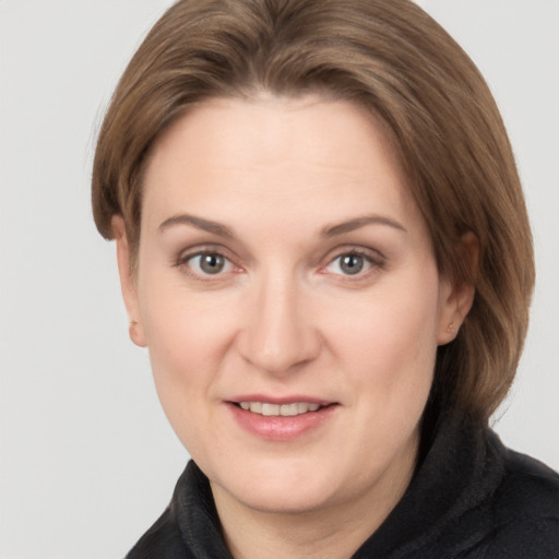 Joyful white adult female with medium  brown hair and grey eyes