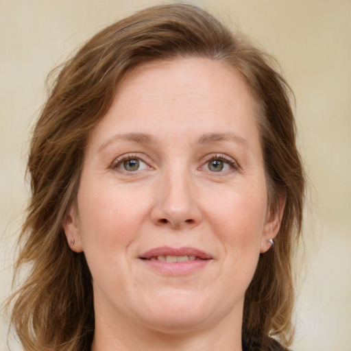 Joyful white adult female with medium  brown hair and green eyes