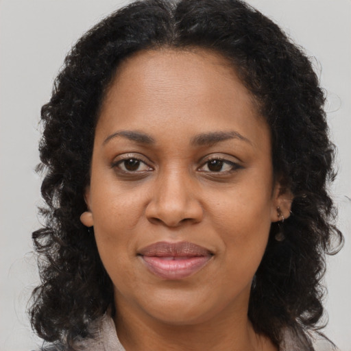 Joyful black adult female with long  brown hair and brown eyes