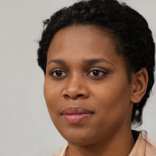 Joyful black young-adult female with short  black hair and brown eyes