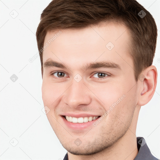 Joyful white young-adult male with short  brown hair and grey eyes