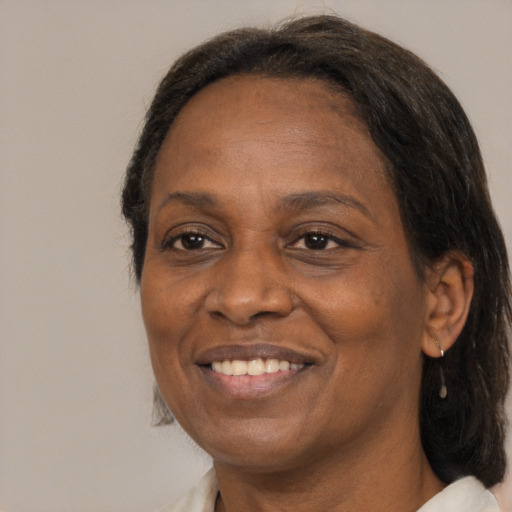 Joyful black adult female with medium  brown hair and brown eyes