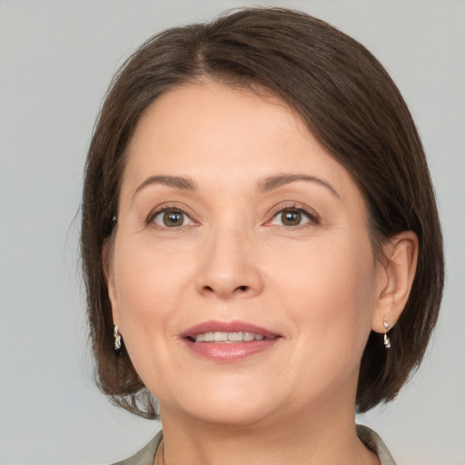 Joyful white adult female with medium  brown hair and brown eyes