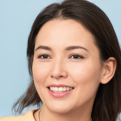 Joyful white young-adult female with long  brown hair and brown eyes