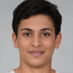 Joyful latino young-adult male with short  brown hair and brown eyes