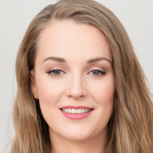 Joyful white young-adult female with long  brown hair and green eyes