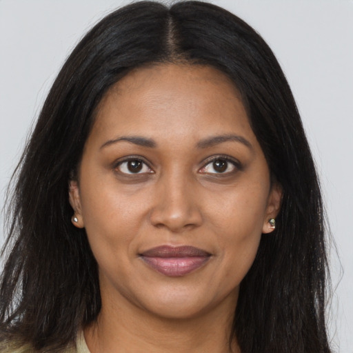 Joyful black adult female with long  brown hair and brown eyes
