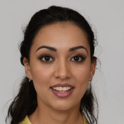 Joyful latino young-adult female with medium  brown hair and brown eyes