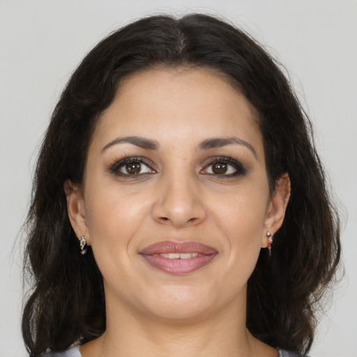 Joyful latino adult female with medium  brown hair and brown eyes