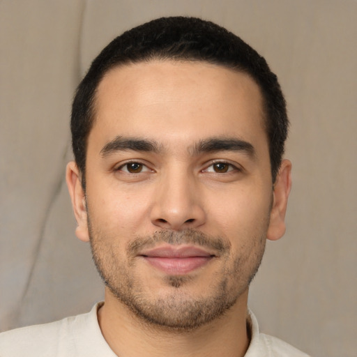 Joyful latino young-adult male with short  black hair and brown eyes