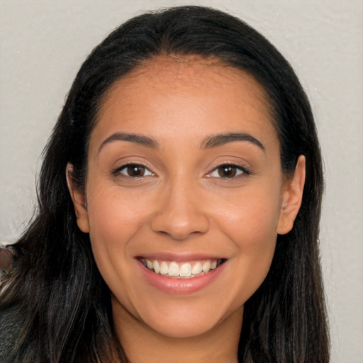 Joyful latino young-adult female with long  brown hair and brown eyes