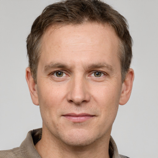 Joyful white adult male with short  brown hair and grey eyes