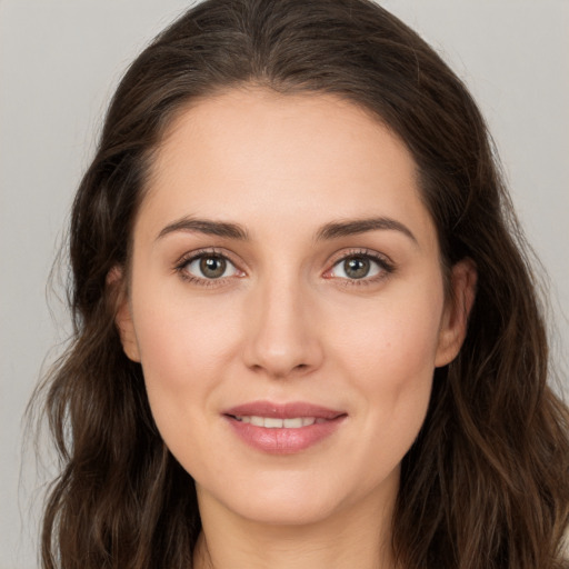 Joyful white young-adult female with long  brown hair and brown eyes