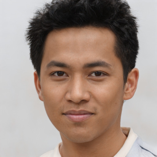 Joyful asian young-adult male with short  black hair and brown eyes