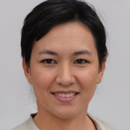 Joyful asian young-adult female with short  brown hair and brown eyes