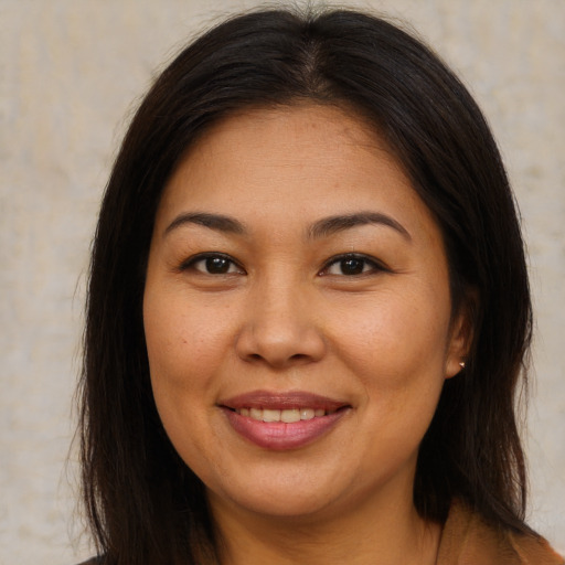 Joyful asian young-adult female with long  brown hair and brown eyes