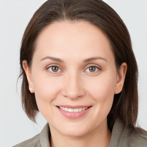 Joyful white young-adult female with medium  brown hair and grey eyes