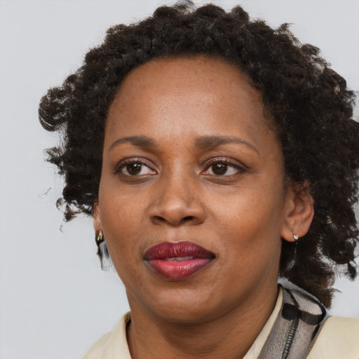 Joyful black adult female with medium  brown hair and brown eyes