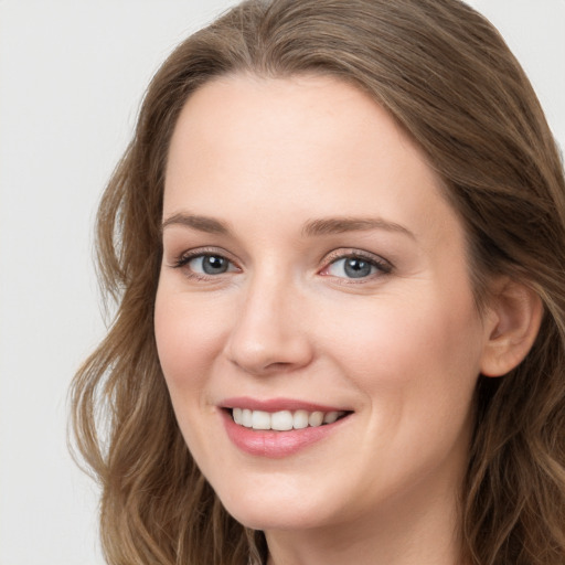 Joyful white young-adult female with long  brown hair and blue eyes