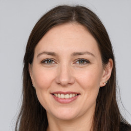 Joyful white adult female with long  brown hair and grey eyes