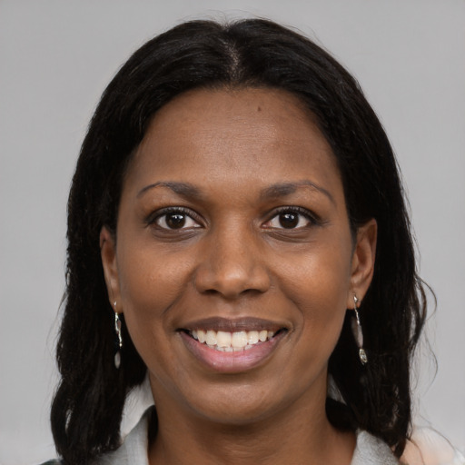 Joyful black young-adult female with medium  brown hair and brown eyes