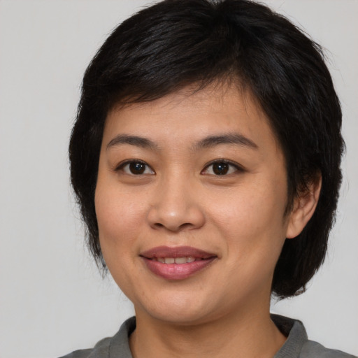 Joyful asian young-adult female with medium  black hair and brown eyes